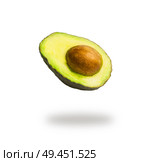 Flying half avocado with seed, isolated on white background with shadow. Concept of food levitation. Стоковое фото, агентство Ingram Publishing / Фотобанк Лори
