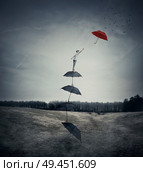 Young boy stand on a stack of umbrellas arranged as a ladder to the sky, trying to catch a different red umbrella. The pursuit of happiness and success concept. Стоковое фото, агентство Ingram Publishing / Фотобанк Лори
