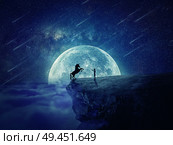 Night scene with a boy standing at the edge of a cliff chasm trying to tame a wild unicorn. Begining of a new friendship, fearless symbol. Стоковое фото, агентство Ingram Publishing / Фотобанк Лори