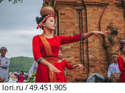 Vietnamese women in traditional red clothes dance in the towers of Nagar Cham in Asia. Nha Trang, Vietnam - December 18, 2024. Редакционное фото, фотограф Корчагина Анастасия / Фотобанк Лори