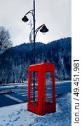 Classic red British telephone box on the snowy street in Sinaia, Carpathian Mountains, Romania. Стоковое фото, агентство Ingram Publishing / Фотобанк Лори