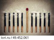 Whole, unused match standing middle a row of extinguished, burnt matches. Standing out from the crowd, leadership concept. Стоковое фото, агентство Ingram Publishing / Фотобанк Лори
