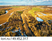 Spring rural aerial landscape. Spring melting snow on march agricultural fields. Railroad passing to Minsk city on background. Winter crops and plowed field. Belarus . Стоковое фото, агентство Ingram Publishing / Фотобанк Лори