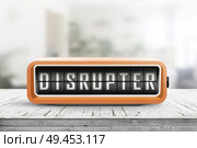Disrupter alarm on a wooden table in a bright room with green plants in the background. Стоковое фото, агентство Ingram Publishing / Фотобанк Лори