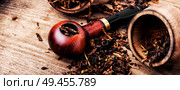 Tobacco pipe or smoking pipe on a wooden table. Smoking pipe and tobacco. Стоковое фото, агентство Ingram Publishing / Фотобанк Лори