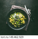 Bowl with potatoes salad with roasted green asparagus, edamame soybeans, lime and green peas on dark rustic kitchen table background, top view. Copy space. Healthy vegetarian food . Стоковое фото, агентство Ingram Publishing / Фотобанк Лори