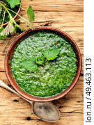 Nettle cream soup on wooden background.Soup with fresh nettles. Russian traditional nettle soup. Стоковое фото, агентство Ingram Publishing / Фотобанк Лори