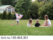 A family with three children. A mother with many children and toddlers in a summer park. Children are walking and flying a kite. Large families, family values, and leisure time with children. Стоковое фото, фотограф Photojuli / Фотобанк Лори