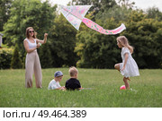 A family with three children. A mother with many children and toddlers in a summer park. Children are walking and flying a kite. Large families, family values, and leisure time with children. Стоковое фото, фотограф Photojuli / Фотобанк Лори