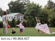 A family with three children. A mother with many children and toddlers in a summer park. Children are walking and flying a kite. Large families, family values, and leisure time with children. Стоковое фото, фотограф Photojuli / Фотобанк Лори