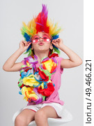Funny beautiful party little girl in disguise with wig in many colors and pink round sunglasses. Funny little girl in disguise with wig and sunglasses. Стоковое фото, агентство Ingram Publishing / Фотобанк Лори