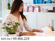 Woman using manicured nails in UV lamp. Small nail art and manicure business. Hands of woman in a wellnes salon. Woman using manicured nails in UV lamp. Стоковое фото, агентство Ingram Publishing / Фотобанк Лори