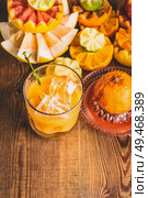 Fresh squeezed citrus juice in glass with ice cubes on table with ingredients:  orange, lemon, grapefruit, mandarin, lime. Healthy lifestyle . Vitamin C source . Colorful citrus fruits. Стоковое фото, агентство Ingram Publishing / Фотобанк Лори