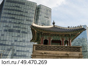 Traditional watchtower in front of skyscraper, Dongsibjagak Watchtower, Seoul, South Korea. Стоковое фото, агентство Ingram Publishing / Фотобанк Лори
