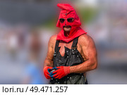 Muscular executioner in red mask and black apron on blurred background. Стоковое фото, фотограф Евгений Ткачёв / Фотобанк Лори