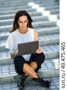 Middle-age businesswoman working with her laptop computer sitting on urban steps outdoors.. Young woman working with her laptop computer sitting on the floor. Стоковое фото, агентство Ingram Publishing / Фотобанк Лори