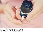 Someone measuring blood sugar level with blood glucose metr, world diabetes day concept, toned. Measurnig blood sugar level. Стоковое фото, агентство Ingram Publishing / Фотобанк Лори