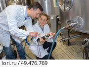 Quality controllers at stainless steel vat. Стоковое фото, агентство Ingram Publishing / Фотобанк Лори