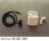 Comparison between 3.5mm jack wired headphones vs wireless earphones for music listening. Pros and cons, opposite contrary. Technology development tendencies, human entertainment conveniences concept. Стоковое фото, агентство Ingram Publishing / Фотобанк Лори