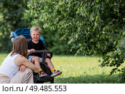 A little boy in a stroller and his mom. Childish hysteria. The child screams, cries, gets cranky and gets hysterical. Discontent. Стоковое фото, фотограф Photojuli / Фотобанк Лори