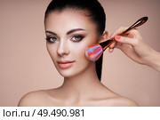 Beautiful Woman applies Skin Tone with Brush. Beautiful Woman face. Perfect Makeup. Skincare Foundation. Brushes Makeup Artist. Стоковое фото, агентство Ingram Publishing / Фотобанк Лори