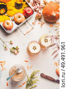 Autumn layout. Glass mugs with apple hot cider or apple mulled wine with apple slices on white desktop with sunflowers, pumpkin and autumn leaves, top view. Fall season enjoy. Copy space Flat lay. Стоковое фото, агентство Ingram Publishing / Фотобанк Лори
