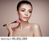 Beautiful Woman applies Skin Tone with Brush. Beautiful Woman face. Perfect Makeup. Skincare Foundation. Brushes Makeup Artist. Стоковое фото, агентство Ingram Publishing / Фотобанк Лори