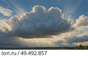 Majestic clouds billow and stretch across a vibrant sky as sunlight streams through, illuminating the rolling hills below. The scene evokes a tranquil yet powerful atmosphere Generative AI. Стоковое AI-изображение, AI-художник Юлия Петровская / Фотобанк Лори