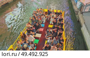 Osaka, Japan - Sep 21 2024, 4k, Panoramic view of Dotonbori river with a ship with tourists, a lot of people on embankment, there are a lot of advertising and illuminations on buildings, Osaka, Japan. Редакционное видео, видеограф Сергей Богомяко / Фотобанк Лори