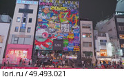 Osaka, Japan - Sep 22 2024, 4k, Panoramic view of Dotonbori river with a ship with tourists, a lot of people on embankment, there are a lot of advertising and illuminations on buildings, Osaka, Japan. Редакционное видео, видеограф Сергей Богомяко / Фотобанк Лори