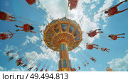 People enjoying a fast-paced carnival ride with colorful lights and exhilarating movement. Стоковое AI-изображение, AI-художник Данила Большаков / Фотобанк Лори