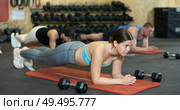 Young girl holding plank pose during bodyweight workout in gym. Стоковое фото, фотограф Яков Филимонов / Фотобанк Лори