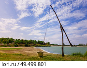 Idyllic countryside scene with an old water well sweep (shadoof) near the Delia lake (Moldova). Also called a counterpoise lift or well pole, is an ancient irrigation tool and used for watering crops. Стоковое фото, агентство Ingram Publishing / Фотобанк Лори