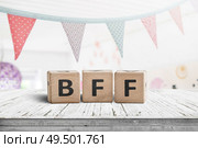 BFF greeting message made of wooden blocks with colorful flags hanging above. Стоковое фото, агентство Ingram Publishing / Фотобанк Лори