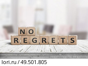 No regrets sign made with wooden blocks on a table in a bright room. Стоковое фото, агентство Ingram Publishing / Фотобанк Лори