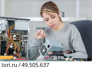 portrait of young woman fixing computer. Стоковое фото, агентство Ingram Publishing / Фотобанк Лори