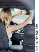 gorgeous brunette fixing up rearview car mirror. Стоковое фото, агентство Ingram Publishing / Фотобанк Лори