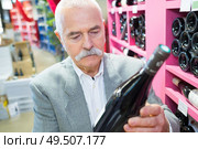 man in a supermarket buying wine. Стоковое фото, агентство Ingram Publishing / Фотобанк Лори