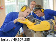 team of workers using a miter saw. Стоковое фото, агентство Ingram Publishing / Фотобанк Лори