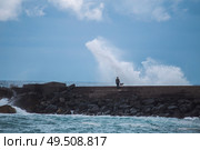 Puerto de la Cruz. fisherman standing on the dock and goes fishing. Big waves. Стоковое фото, агентство Ingram Publishing / Фотобанк Лори