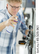 mature mechanic fixes a bike wheel. Стоковое фото, агентство Ingram Publishing / Фотобанк Лори