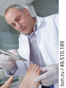 the doctor-podiatrist does an examination of the patients foot. Стоковое фото, агентство Ingram Publishing / Фотобанк Лори