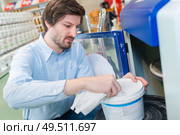 worker pulling wet wipe from commercial sized tub. Стоковое фото, агентство Ingram Publishing / Фотобанк Лори
