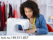young attractive needlewoman at studio working with sewing machine. Стоковое фото, агентство Ingram Publishing / Фотобанк Лори