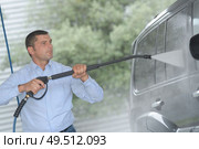 handsome man is cleaning car outdoor. Стоковое фото, агентство Ingram Publishing / Фотобанк Лори