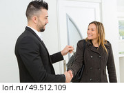 two businessperson shaking hands as keys are given. Стоковое фото, агентство Ingram Publishing / Фотобанк Лори