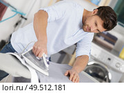 man ironing shirt on iron board at home. Стоковое фото, агентство Ingram Publishing / Фотобанк Лори