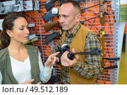 Man in hunting shop looking at rifle. Стоковое фото, агентство Ingram Publishing / Фотобанк Лори