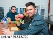 portrait of manual worker eating apple on lunch break. Стоковое фото, агентство Ingram Publishing / Фотобанк Лори
