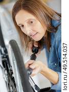 woman pumping on a bicycle wheel. Стоковое фото, агентство Ingram Publishing / Фотобанк Лори